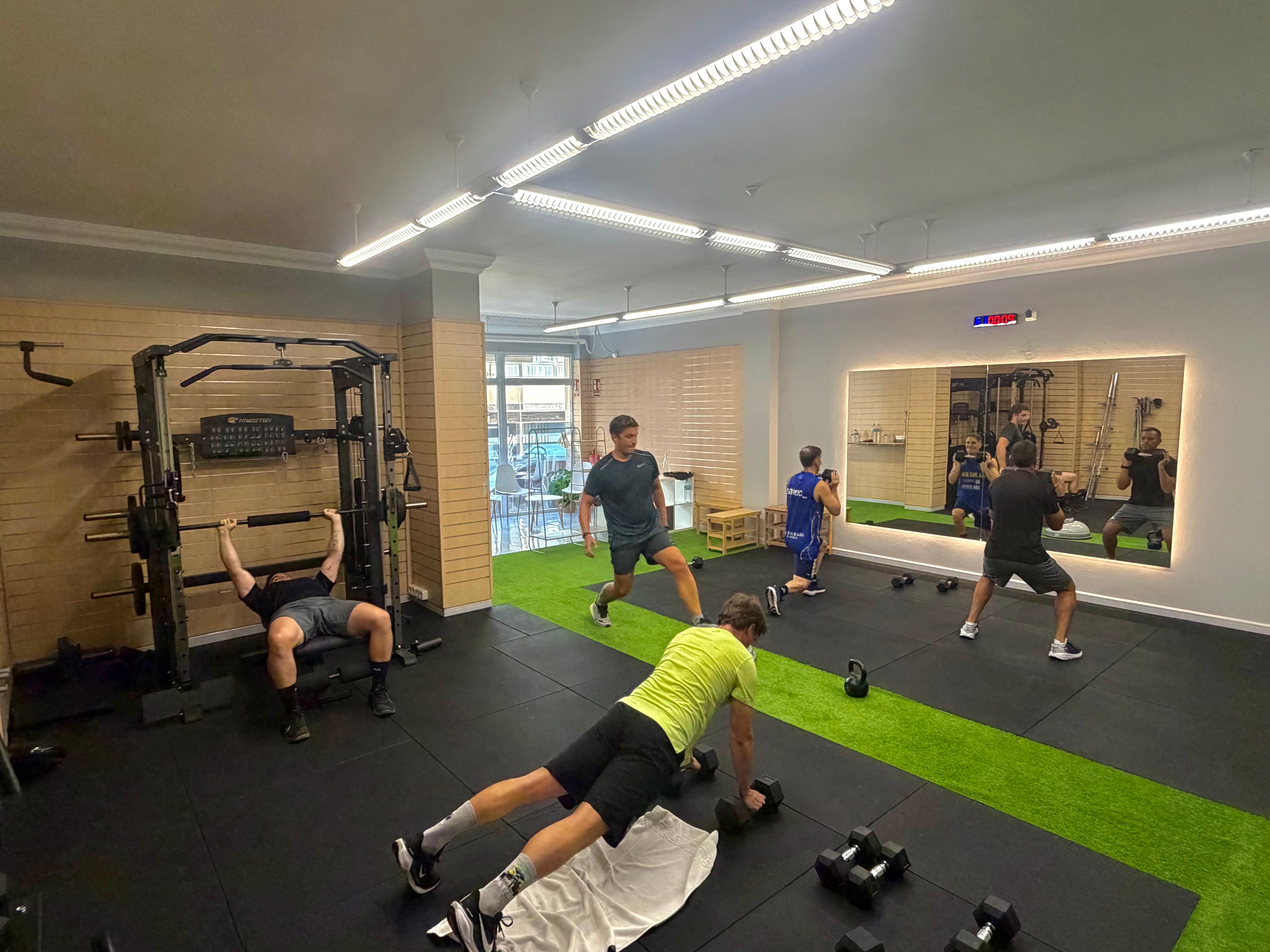 Entrenador personal guiant un exercici funcional